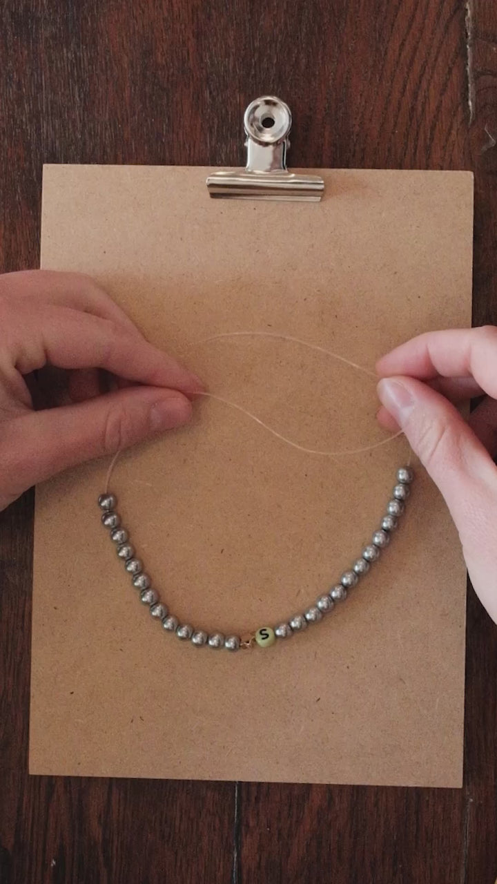 Fermer un bracelet de perles avec un nœud de chirurgien